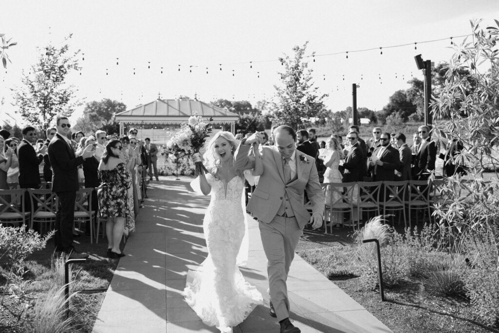 bride and groom kiss during summer wedding ceremony